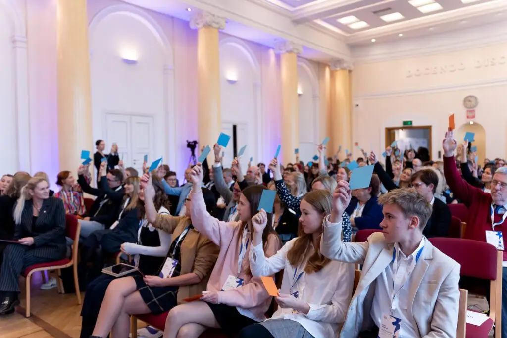 Summit participants raising voting cards during a debate