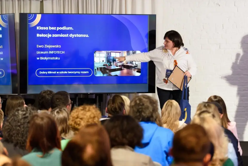 A teacher presenting her school’s project to an audience during the school climate contest
