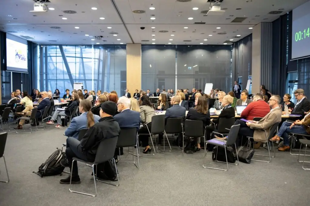 Participants seated at tables in a large conference hall during the first Summit for Education